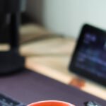 Computer Snail - A coffee cup sits on a desk next to a computer