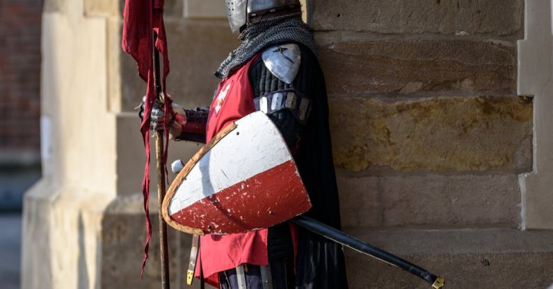 Security Shield - Man Wearing Gray and Red Armour Standing on the Streets