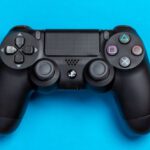 Game Controller - Flat Lay Photo of Black Sony PS4 Game Controller on Blue Background