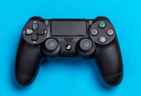 Game Controller - Flat Lay Photo of Black Sony PS4 Game Controller on Blue Background