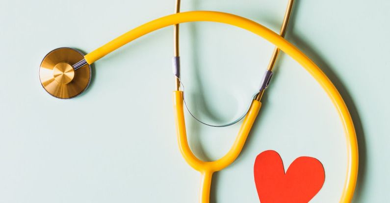 Diagnostic Tool - Medical stethoscope with red paper heart on white surface