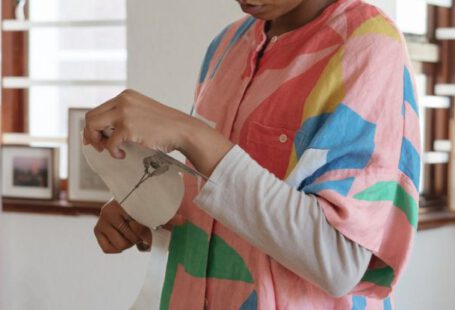 Manual Book - Concentrated female designer preparing paper cutouts for creative project