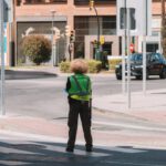 Troubleshooting Guide - A person standing on a street corner with a green jacket