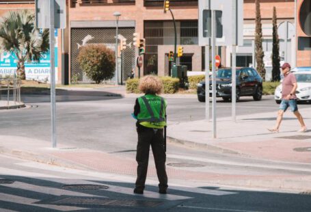 Troubleshooting Guide - A person standing on a street corner with a green jacket