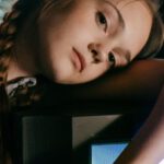 Video Game Settings - Tired teen leaning with hand on shiny monitor