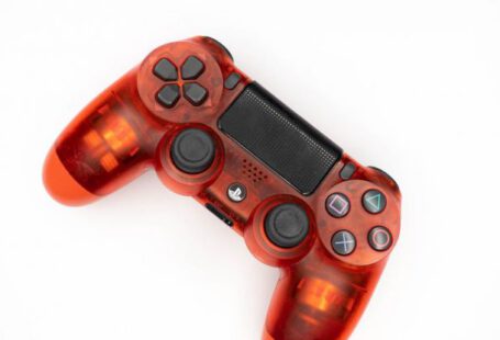 Gamepad Tool - Top view of modern orange gamepad for game console placed on white background