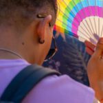 Dust Fan - A man holding a colorful fan in the street