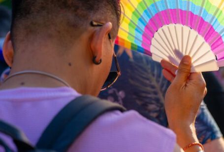 Dust Fan - A man holding a colorful fan in the street