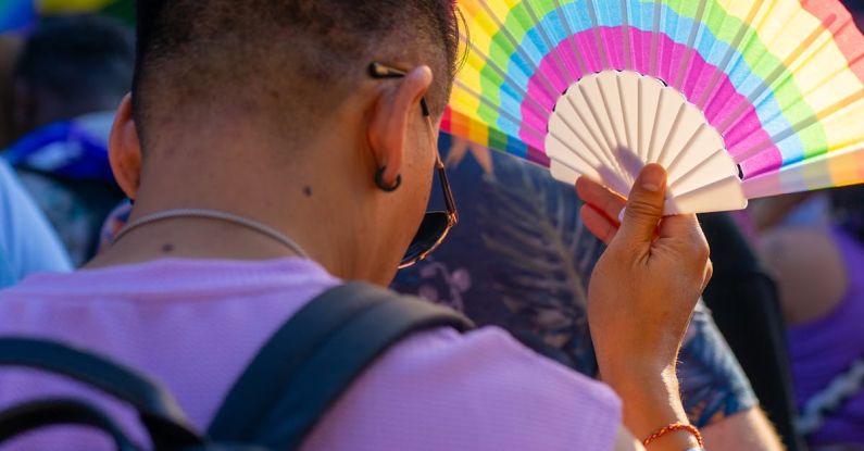 Dust Fan - A man holding a colorful fan in the street