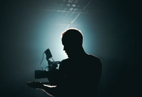 Settings Gear - Silhouette of Man Standing in Front of Microphone