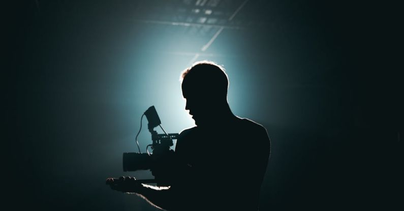 Settings Gear - Silhouette of Man Standing in Front of Microphone