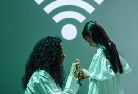 Wifi Signal - Woman in White Scrubs Connecting a Smartwatch of a Girl to Wifi