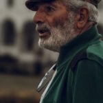 Profile Avatar - Profile of a Senior Man Wearing a Hat, against a Mosque