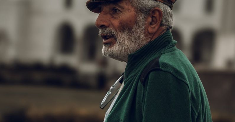 Profile Avatar - Profile of a Senior Man Wearing a Hat, against a Mosque