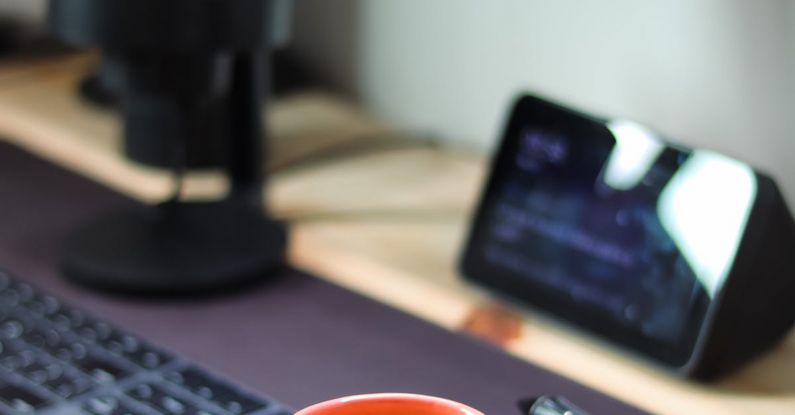 Computer Snail - A coffee cup sits on a desk next to a computer